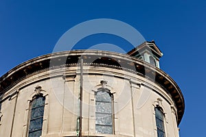 Exterior of a stone church building with stained glass windows, verdigris copper details against a deep blue sky photo