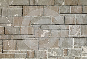 Exterior stone wall coating made by gray granite rock tiles of differen sizes.