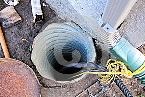 An exterior sump pump installed next to a house