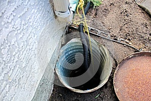 An exterior sump pump installed next to a house