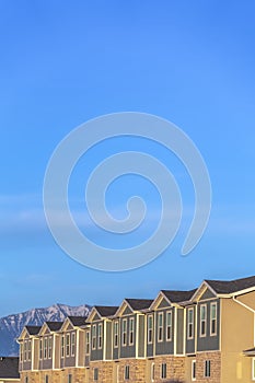 Exterior of townhomes with mountain peak and blue sky background on a sunny day
