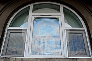Exterior view of arched window with decorative objects on the sill