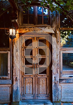 Exterior view and front door of beautiful old traditional house. The entrance is covered with ivy. wooden house