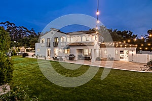 the exterior view of the home at night with string lights