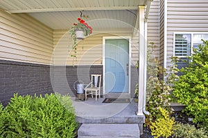 Exterior view of a home with stepas and porch in front of the pastel blue door