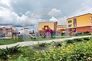 Exterior view of modern public school building with playground.