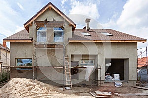 Exterior view of new house under construction and painting. External plaster of the walls of a two-story house.