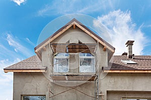 Exterior view of new house under construction and painting. External plaster of the walls of a two-story house.