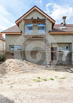 Exterior view of new house under construction and painting. Scaffolding for exterior plastering at home.