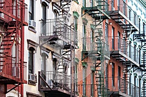 Exterior view of old apartment buildings with fire escapes on 6th Street in the East Village neighborhood of New York City