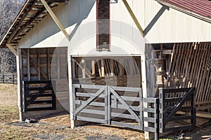 Exterior view of old open horse barn, winter