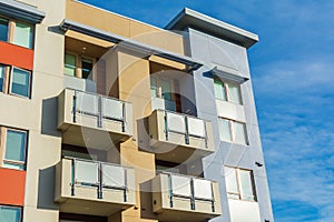 Exterior view of typical new multifamily mid-rise residential building with balconies. The buildings usually rental apartments,