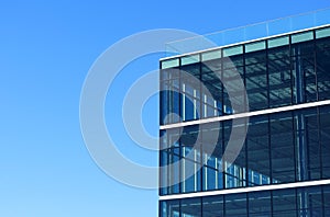 Exterior view of a vacant brand new modern office building. Typical glass facade of generic modern commercial building. Blue sky