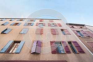 Exterior wall with many windows and shutters, building and architecture Narbonne, France.