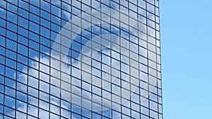 Exterior wall of mordern office building, floating clouds reflecting on glasses