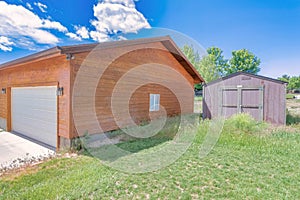 Exterior of a wooden garage and tool shed with grass