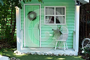 Exterior Wooden porch home with garden furniture. Facade green wooden house decorated for spring holidays