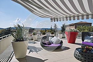 Exteriors shots of a modern terrace with awnings and sofas