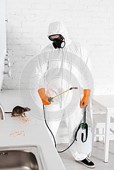 Exterminator holding toxic spray and looking
