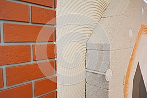 External brick wall insulation. House brick wall insualtion with glue plastering layers,  reinforcment mesh, aerated concrete