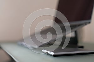 External hard drive in silver color on a computer desk against a blurred laptop