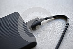 External hard drive with usb cable on a gray background