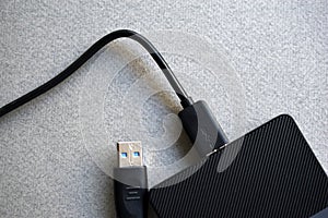 External hard drive with usb cable on a gray background