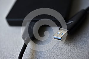 External hard drive with usb cable on a gray background