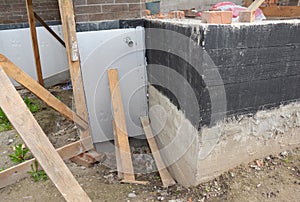 External house basement foundation wall insulation with rigid foam board before waterproofing