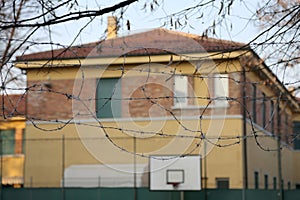 external view of a reformatory with a basketball court and barbed wire