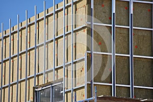 External wall insulation, house wall heat insulation with mineral wool, building under construction.