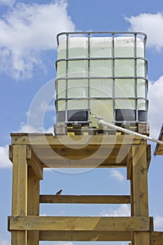 External water tank on a wooden base, water is piped into the house photo