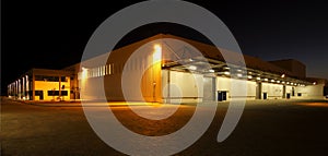 External wide angle view of modern warehouse at night