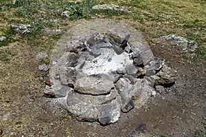 Extinct camp fire place surrounded with rocks or stones, photo of nature