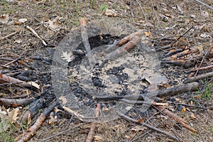 an extinct fire made of black ash and ash on the brown ground