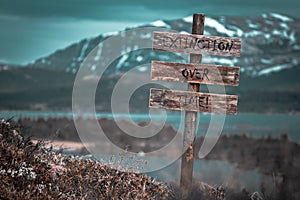 extinction over time text quote engraved on wooden signpost outdoors in landscape looking polluted