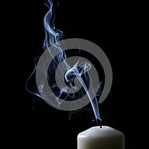 Extinguished candle with blue smoke