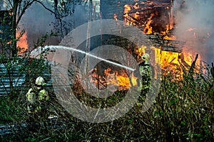 extinguishing the fire of a wooden house photo