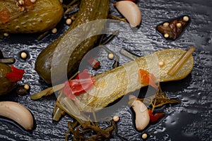 Extra Fine Cornichons - minuscule sour French pickles on natural stone background. Mini French style Gherkin Cucumbers