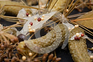 Extra Fine Cornichons - minuscule sour French pickles on natural stone background. Mini French style Gherkin Cucumbers