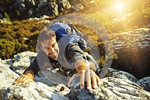 That extra oomph gets you to the top. a young man hiking up a mountain.