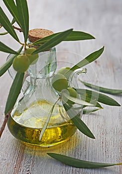 Extra-virgin olive oil bottle and green olivas photo