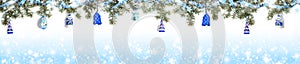 Extra wide Christmas border with fir branches, snow, shiny ribbon, christmas toys on gradient blue background with snow.