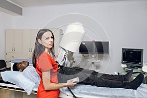 Extracorporeal shock wave lithotripsy. Non-invasive procedure for stone treatment. Young professional lady doctor using photo