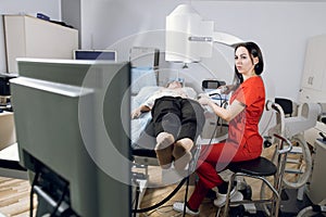 Extracorporeal shock wave therapy. Kidney stone treatment. Front view of woman doctor looking at the digital screen of