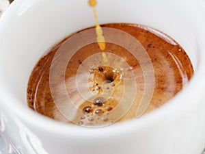 Extraction of espresso with rich crema in cup photo