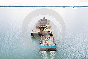 Extraction of sand from the river, excavator digs out sand from the bottom of the lake and unloads it on a floating barge, mining