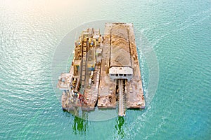 Extraction of sand from the river, excavator digs out sand from the bottom of the lake and unloads it on a floating barge, mining