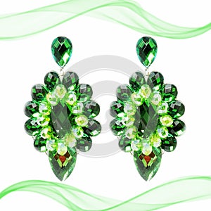 Extravagant big green earrings on a white background with decoration