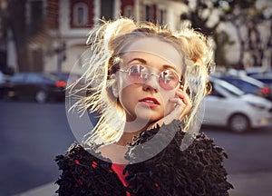 Extravagant blonde girl in rose glasses